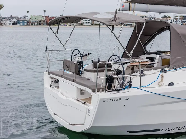 In Stock #042 Yacht Photos Pics 2023 Dufour 37 sailboat docked in a marina, featuring dual steering wheels.