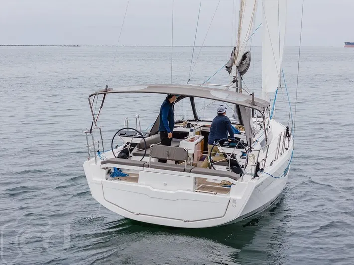 In Stock #042 Yacht Photos Pics 2023 Dufour 37 sailboat on calm waters, featuring dual steering wheels and a spacious deck.