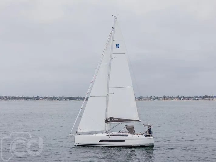 In Stock #042 Yacht Photos Pics 2023 Dufour 37 sailboat on calm waters, overcast sky in the background.