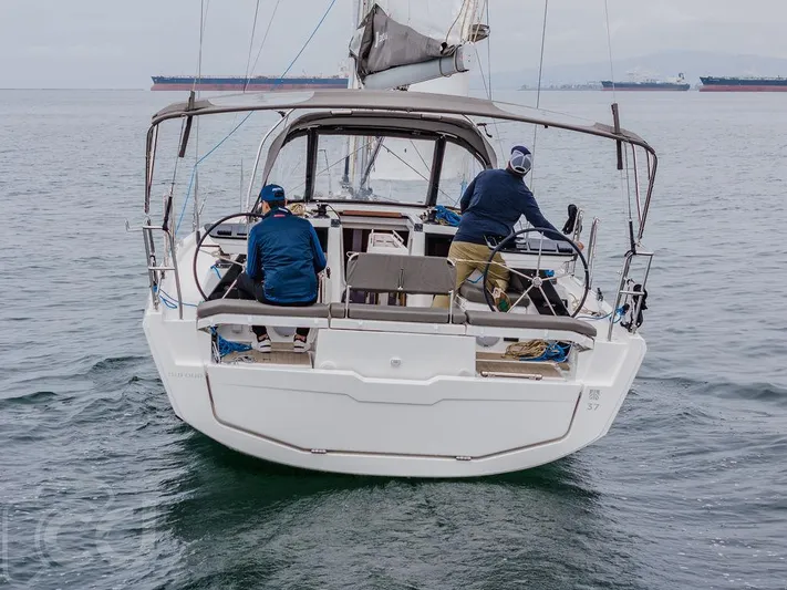 In Stock #042 Yacht Photos Pics 2023 Dufour 37 sailboat on open water with two people onboard.