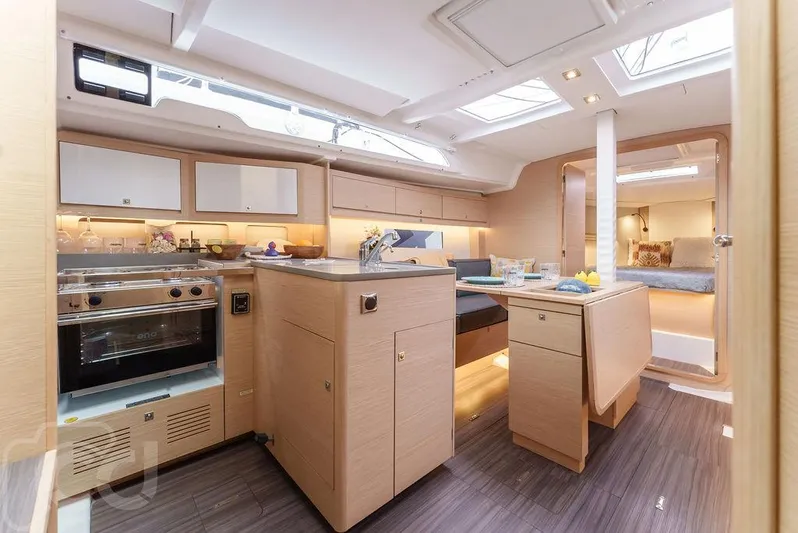 In Stock #042 Yacht Photos Pics Modern interior of 2023 Dufour 37 yacht, featuring sleek kitchen and dining area.