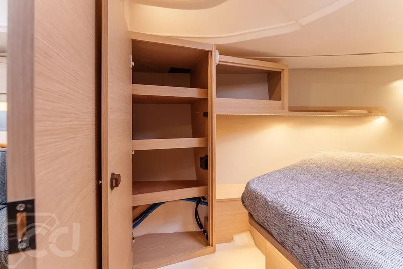 In Stock #042 Yacht Photos Pics Interior of 2023 Dufour 37 yacht showing wooden storage shelves and cozy sleeping area.