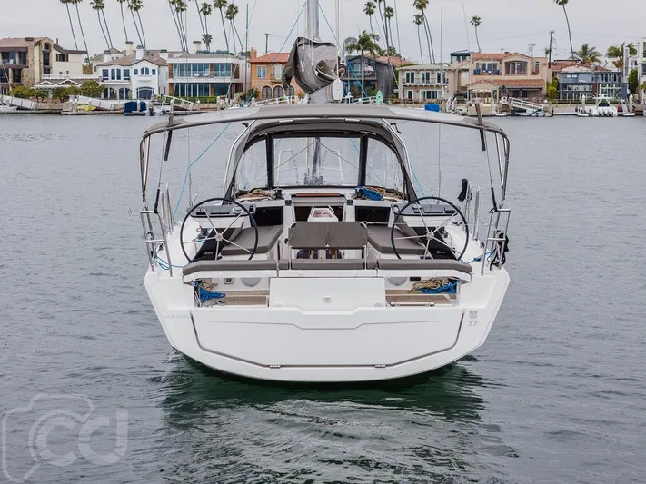 In Stock #042 Yacht Photos Pics 2023 Dufour 37 yacht docked in a marina with waterfront homes in the background.