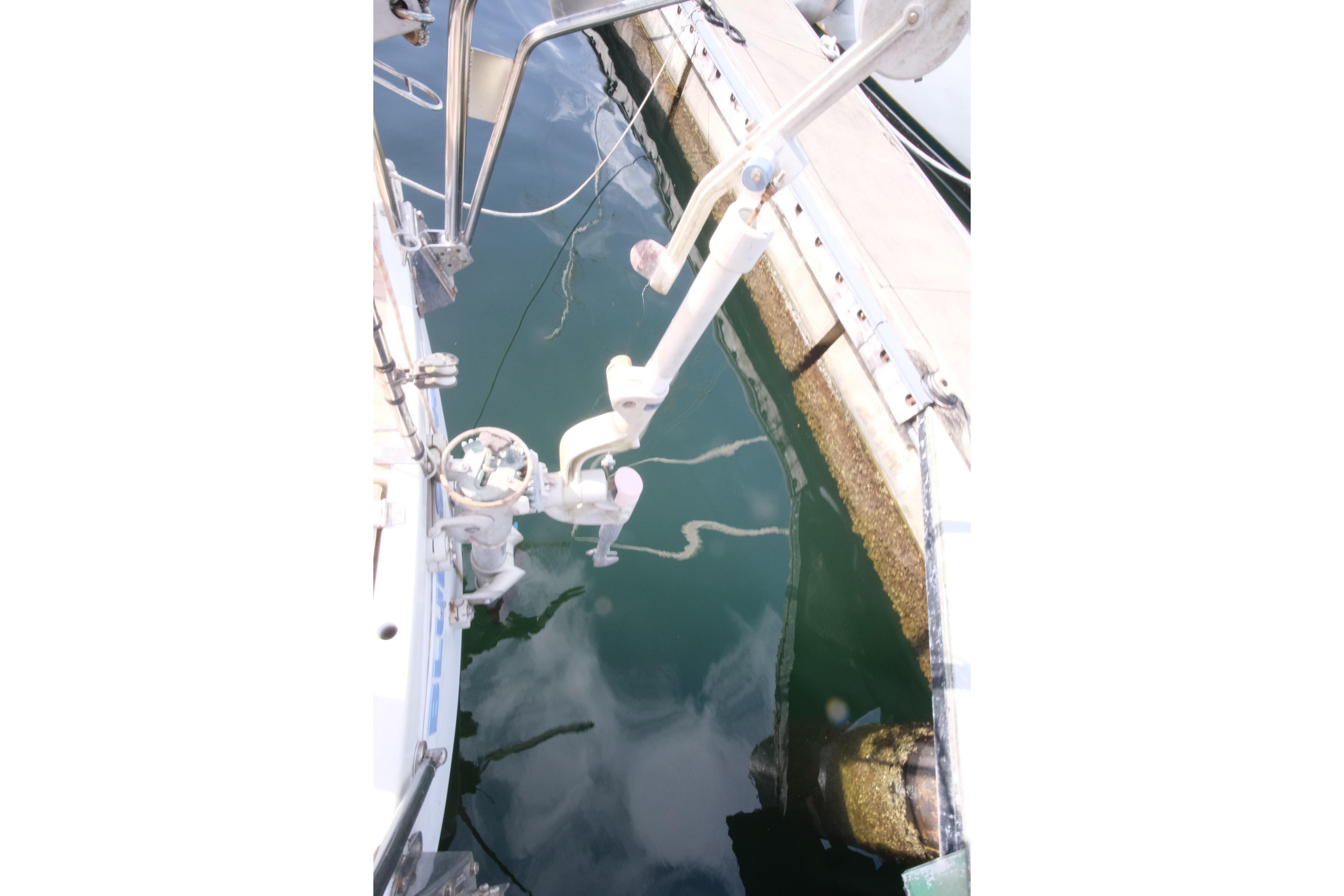 Sailboat stern view, Amel Maramu 45, 1984, docked with visible water reflections.