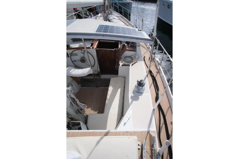 Blue Song Yacht Photos Pics 1984 Amel Maramu 45 sailboat cockpit with solar panel and steering wheel.