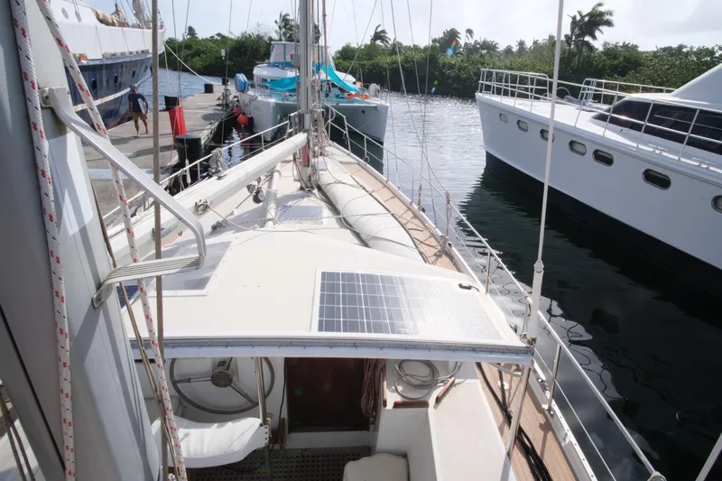 Blue Song Yacht Photos Pics 1984 Amel Maramu 45 sailboat docked, featuring solar panel and spacious deck.