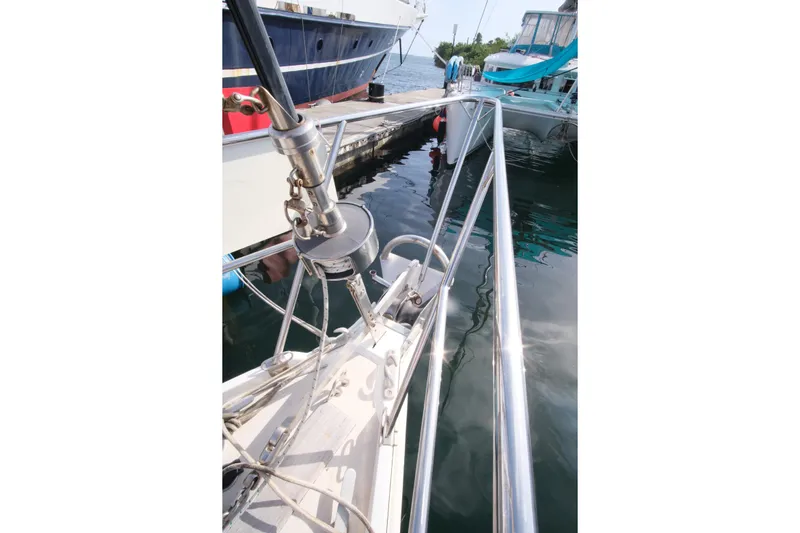 Blue Song Yacht Photos Pics 1984 Amel Maramu 45 sailboat bow at marina, featuring stainless steel rigging and calm water.