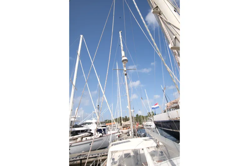 Blue Song Yacht Photos Pics 1984 Amel Maramu 45 sailboat docked, masts and rigging against a clear blue sky.