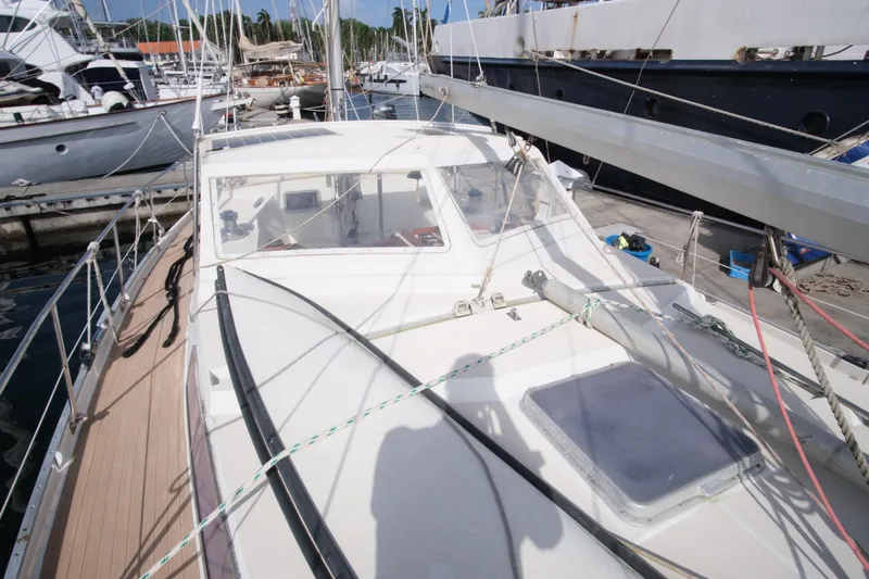 Blue Song Yacht Photos Pics 1984 Amel Maramu 45 sailboat docked at a marina, showcasing deck and cockpit area.