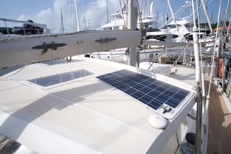 Blue Song Yacht Photos Pics 1984 Amel Maramu 45 sailboat with solar panel on deck, docked at marina.