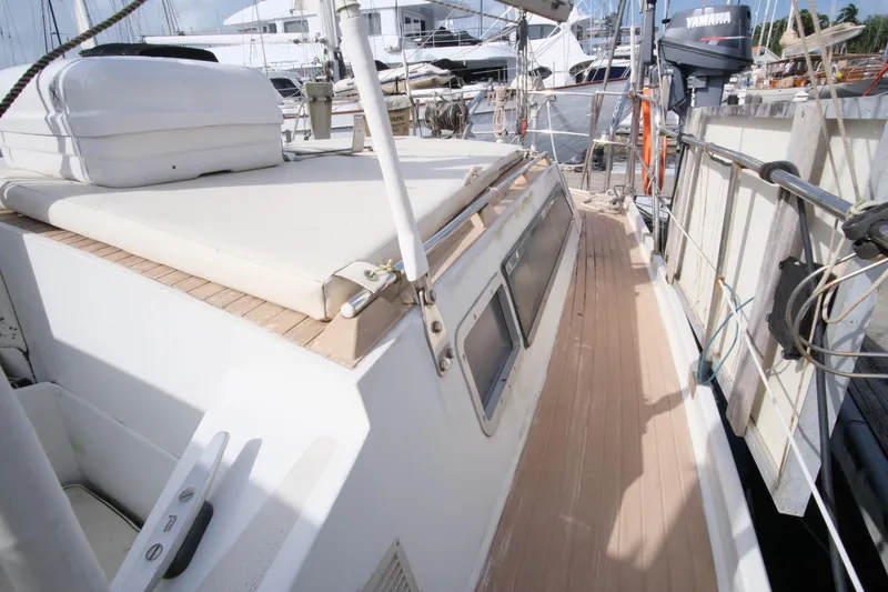 Blue Song Yacht Photos Pics 1984 Amel Maramu 45 sailboat deck with wooden flooring and docked surroundings.