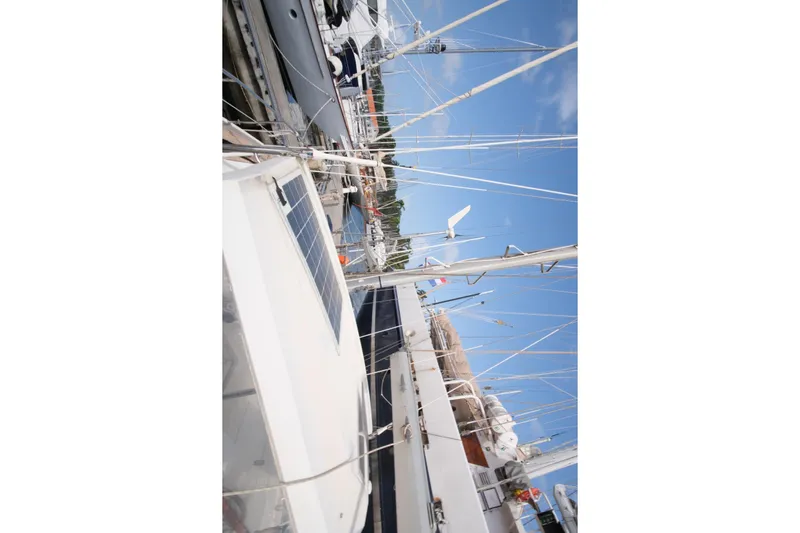Blue Song Yacht Photos Pics 1984 Amel Maramu 45 sailboat docked, featuring solar panels and clear blue sky.