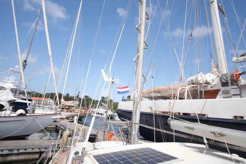 Blue Song Yacht Photos Pics 1984 Amel Maramu 45 sailboat docked in a marina with clear blue skies.