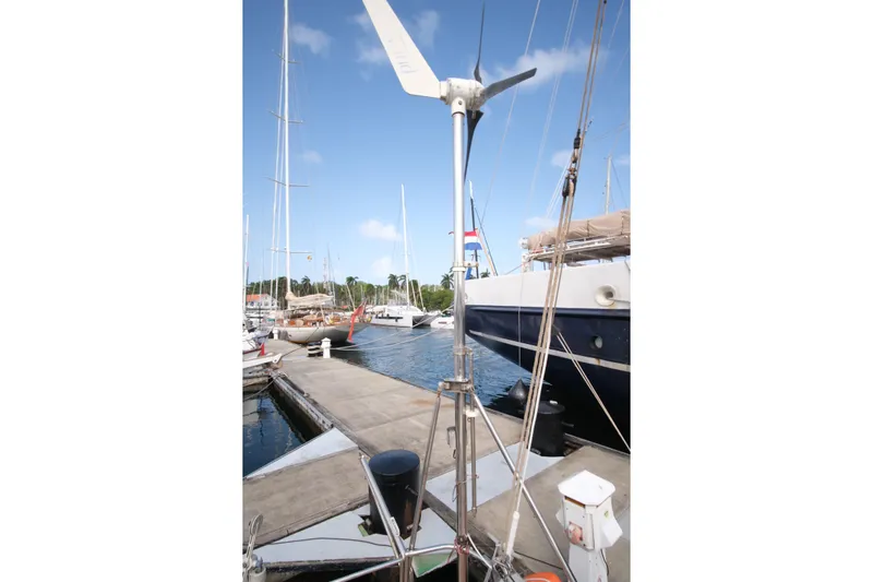 Blue Song Yacht Photos Pics Sailboat docked at marina, featuring wind turbine, Amel Maramu 45, 1984 model.