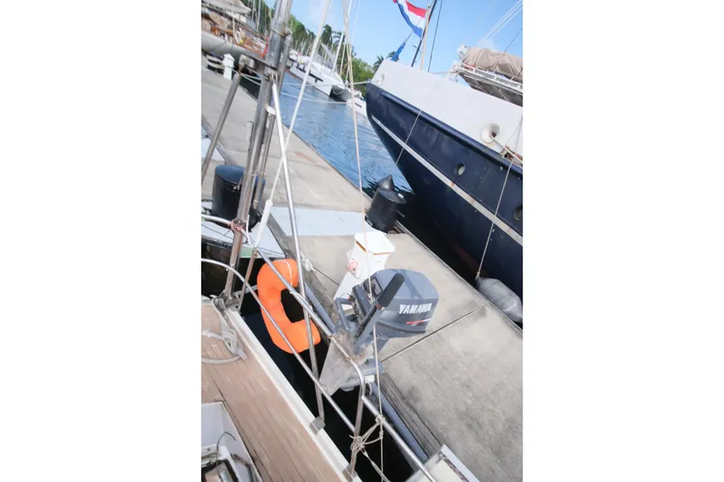 Blue Song Yacht Photos Pics 1984 Amel Maramu 45 sailboat docked with Yamaha outboard motor and lifebuoy.