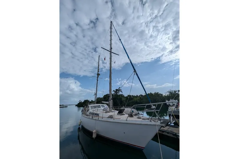 Blue Song Yacht Photos Pics 1984 Amel Maramu 45 sailboat docked under a partly cloudy sky.