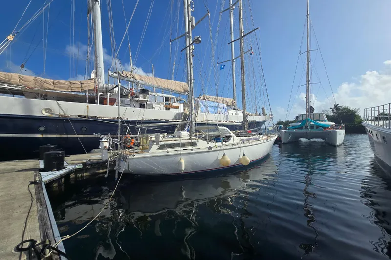 Blue Song Yacht Photos Pics 1984 Amel Maramu 45 sailboat docked in a marina under clear blue skies.