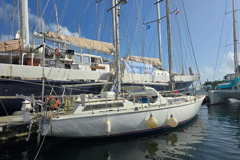 Blue Song Yacht Photos Pics 1984 Amel Maramu 45 sailboat docked in a marina under clear blue skies.