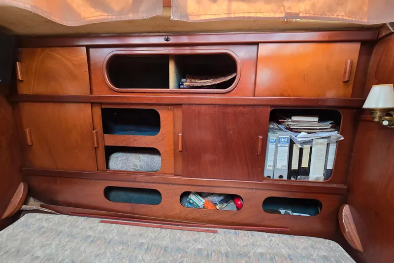 Blue Song Yacht Photos Pics Interior of 1984 Amel Maramu 45 sailboat with wooden cabinets and storage compartments.