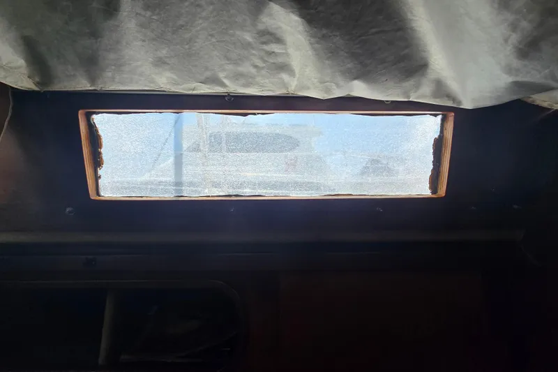 Blue Song Yacht Photos Pics Interior view of 1984 Amel Maramu 45 sailboat window with sunlight filtering through.