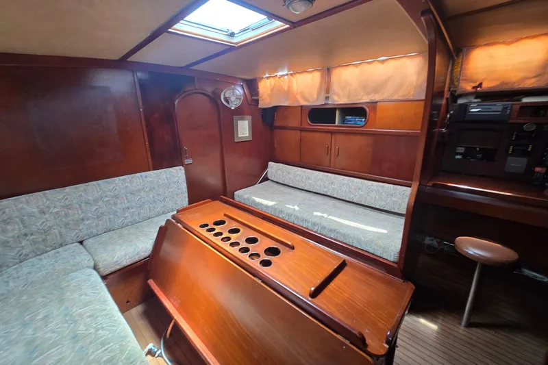 Blue Song Yacht Photos Pics Interior of 1984 Amel Maramu 45 sailboat with wooden furnishings and seating area.
