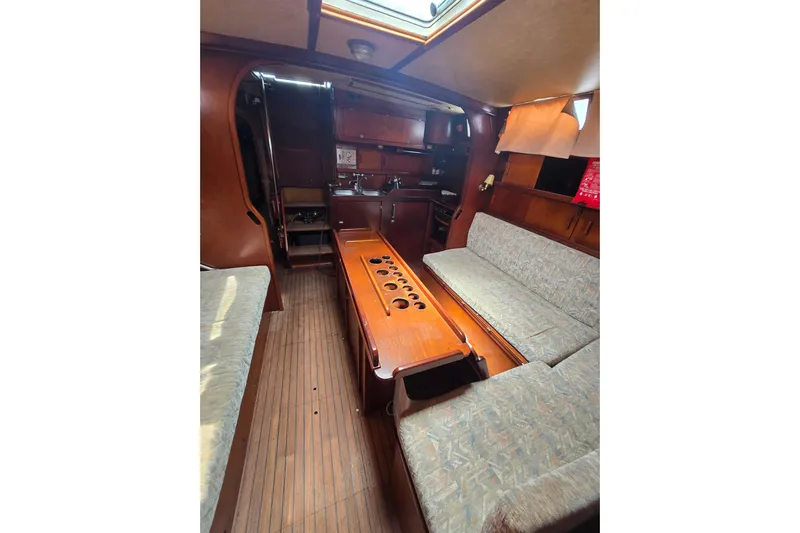 Blue Song Yacht Photos Pics Interior of 1984 Amel Maramu 45 sailboat with wood finish and seating area.
