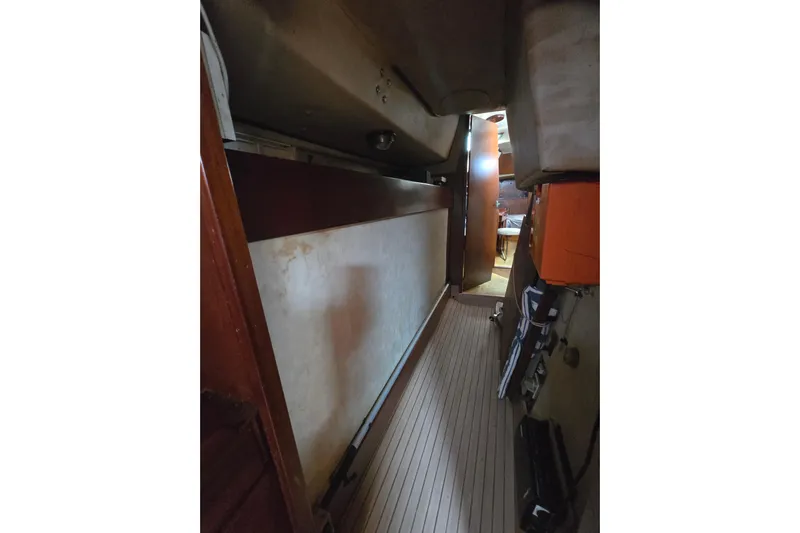 Blue Song Yacht Photos Pics Interior view of 1984 Amel Maramu 45 sailboat, featuring narrow passageway and wooden finishes.