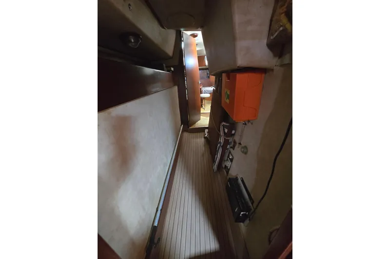 Blue Song Yacht Photos Pics Narrow corridor inside 1984 Amel Maramu 45 sailboat, featuring wooden flooring and storage compartments.