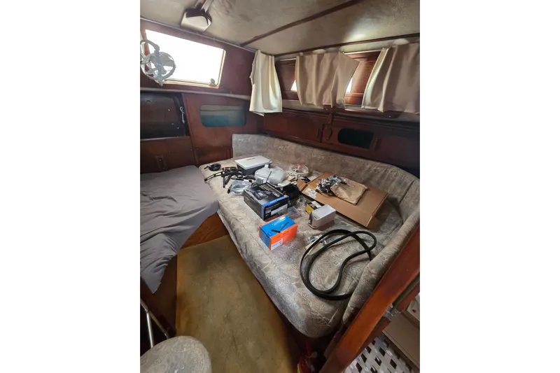 Blue Song Yacht Photos Pics 1984 Amel Maramu 45 yacht interior with various equipment on a cushioned bench.