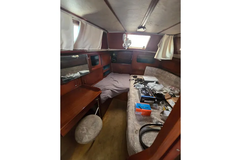 Blue Song Yacht Photos Pics Interior of 1984 Amel Maramu 45 sailboat with wooden furnishings and scattered items.