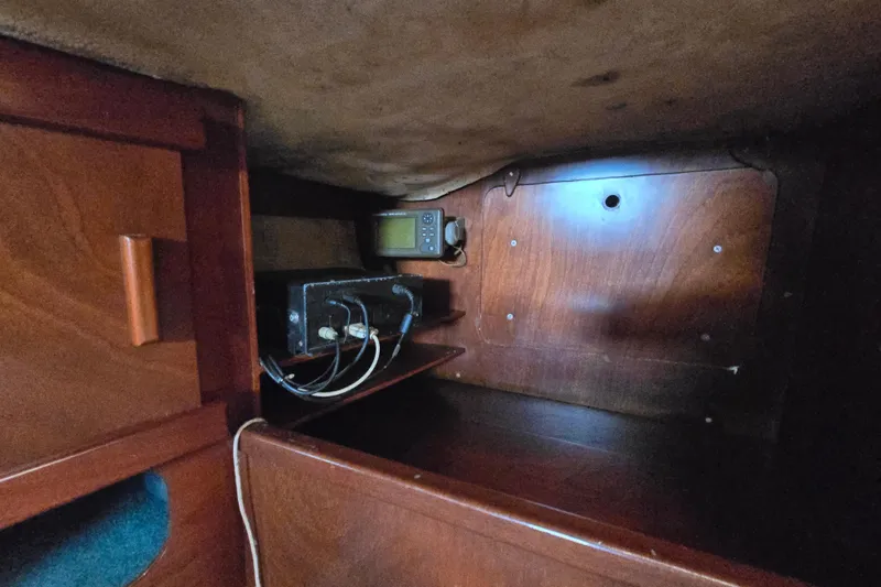 Blue Song Yacht Photos Pics Interior of 1984 Amel Maramu 45 sailboat with wooden cabinetry and electronic equipment.