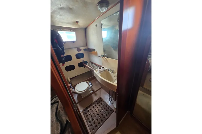 Blue Song Yacht Photos Pics 1984 Amel Maramu 45 yacht bathroom with sink, toilet, and window.