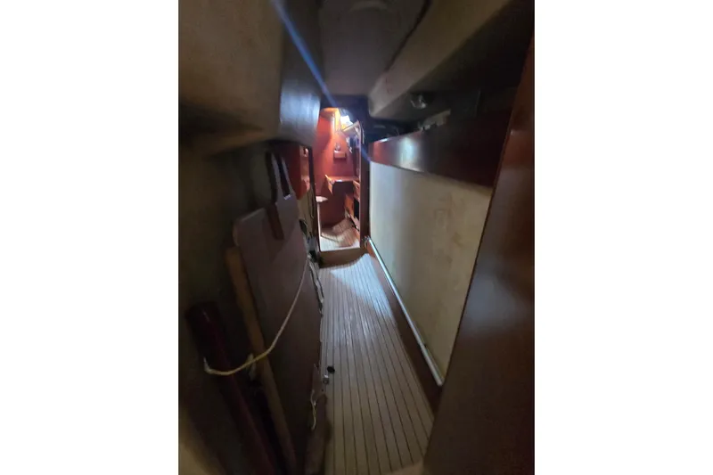 Blue Song Yacht Photos Pics Interior view of 1984 Amel Maramu 45 sailboat, featuring narrow wooden passageway.