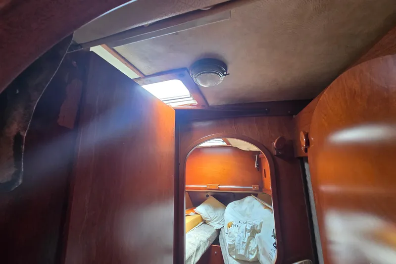 Blue Song Yacht Photos Pics Interior of 1984 Amel Maramu 45 sailboat cabin with wooden finish and cozy bedding.