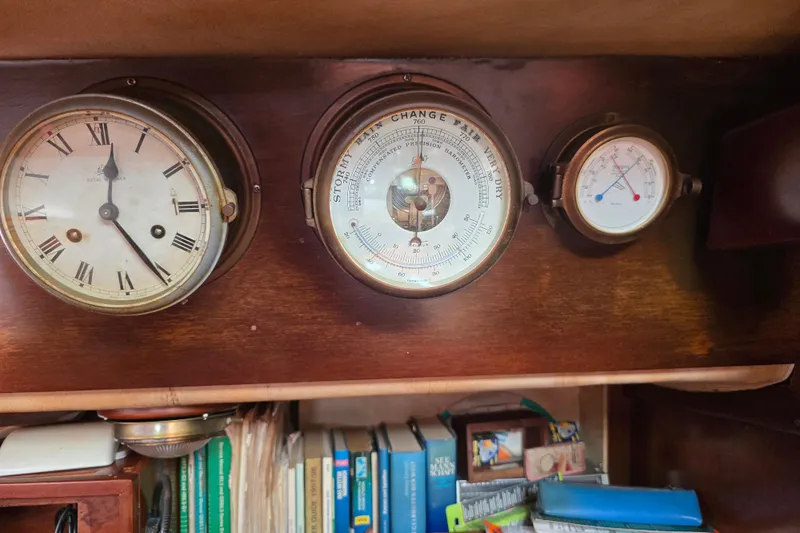 Blue Song Yacht Photos Pics Vintage nautical instruments on 1984 Amel Maramu 45 yacht, featuring clock, barometer, and thermometer.
