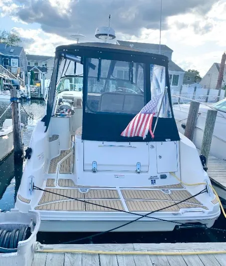  Yacht Photos Pics 2016 Sea Ray 330 Sundancer docked, featuring American flag and covered cockpit.