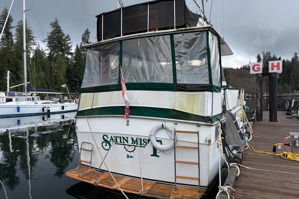 1977 Pacemaker 40 Motor Yacht docked, featuring green and white exterior with covered deck.