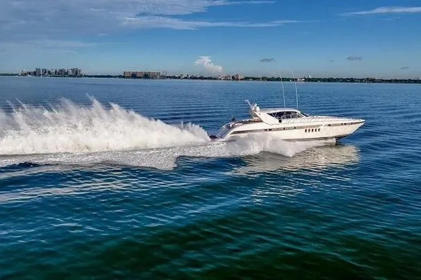  Yacht Photos Pics 1999 Mangusta 80 yacht cruising swiftly on open water under a clear sky.