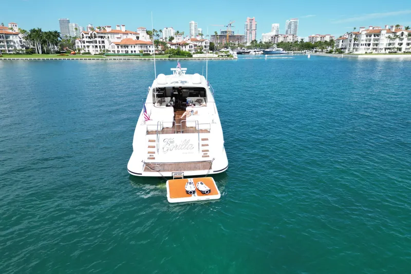  Yacht Photos Pics Luxury 1999 Mangusta 80 yacht on serene water with cityscape background.