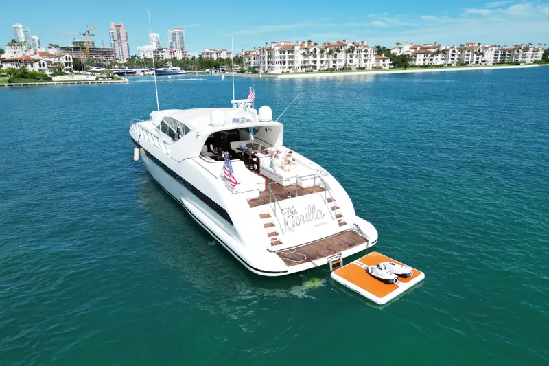  Yacht Photos Pics Luxury 1999 Mangusta 80 yacht on serene water with cityscape background.