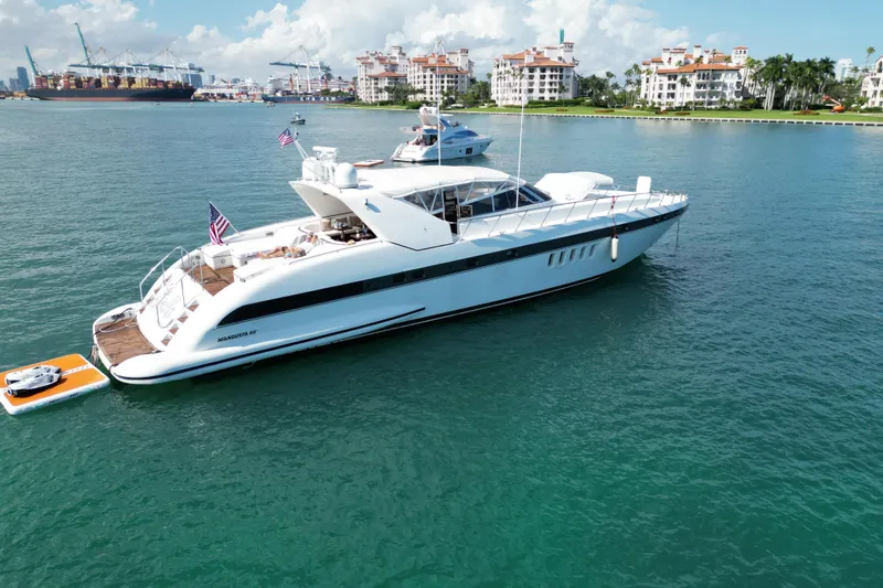  Yacht Photos Pics Luxurious 1999 Mangusta 80 yacht docked in scenic harbor with cityscape background.