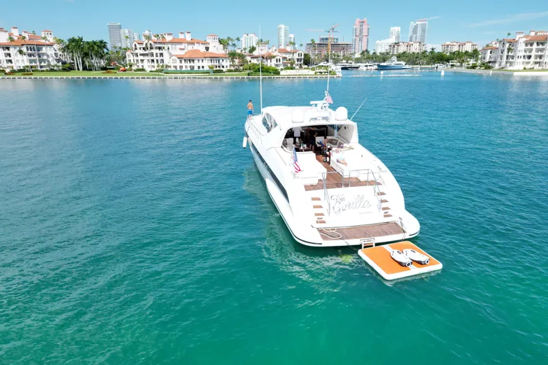  Yacht Photos Pics Luxurious 1999 Mangusta 80 yacht on serene blue waters near coastal residences.