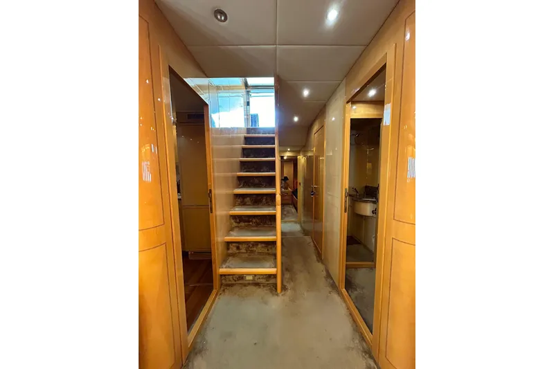  Yacht Photos Pics Interior of 1999 Mangusta 80 yacht with wooden paneling and staircase.