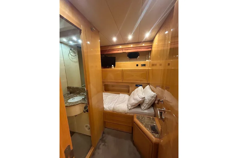  Yacht Photos Pics Luxurious cabin interior of a 1999 Mangusta 80 yacht with bed and ensuite bathroom.