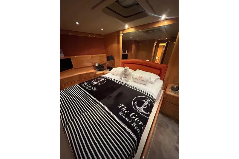  Yacht Photos Pics Luxurious bedroom interior of a 1999 Mangusta 80 yacht with elegant bedding and ambient lighting.
