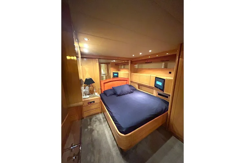  Yacht Photos Pics Luxurious 1999 Mangusta 80 yacht bedroom with wood paneling and modern amenities.