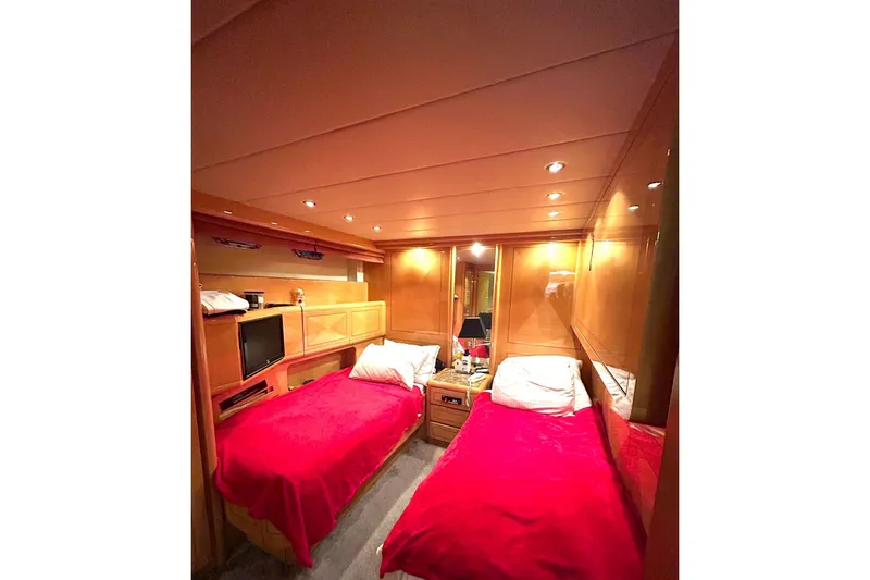  Yacht Photos Pics Luxurious 1999 Mangusta 80 yacht cabin with twin beds and warm wood paneling.