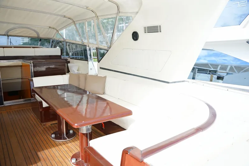  Yacht Photos Pics Luxurious 1999 Mangusta 80 yacht interior with elegant seating and wooden table.
