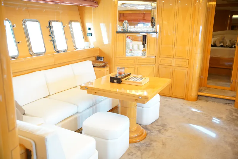 Yacht Photos Pics Luxurious interior of a 1999 Mangusta 80 yacht with elegant wood finishes and plush seating.