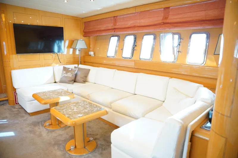  Yacht Photos Pics Luxurious 1999 Mangusta 80 yacht interior with white sofa, wooden accents, and large windows.